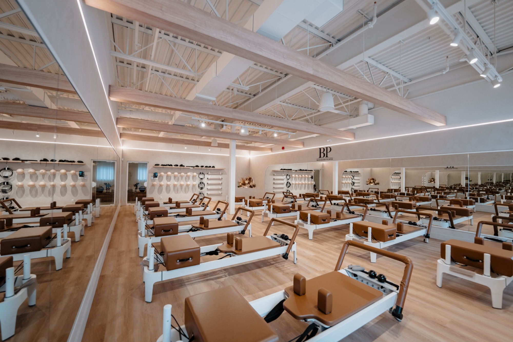 Plateau de reformers du studio Blackburn Pilates Blainville, mur miroité et médaillon BP