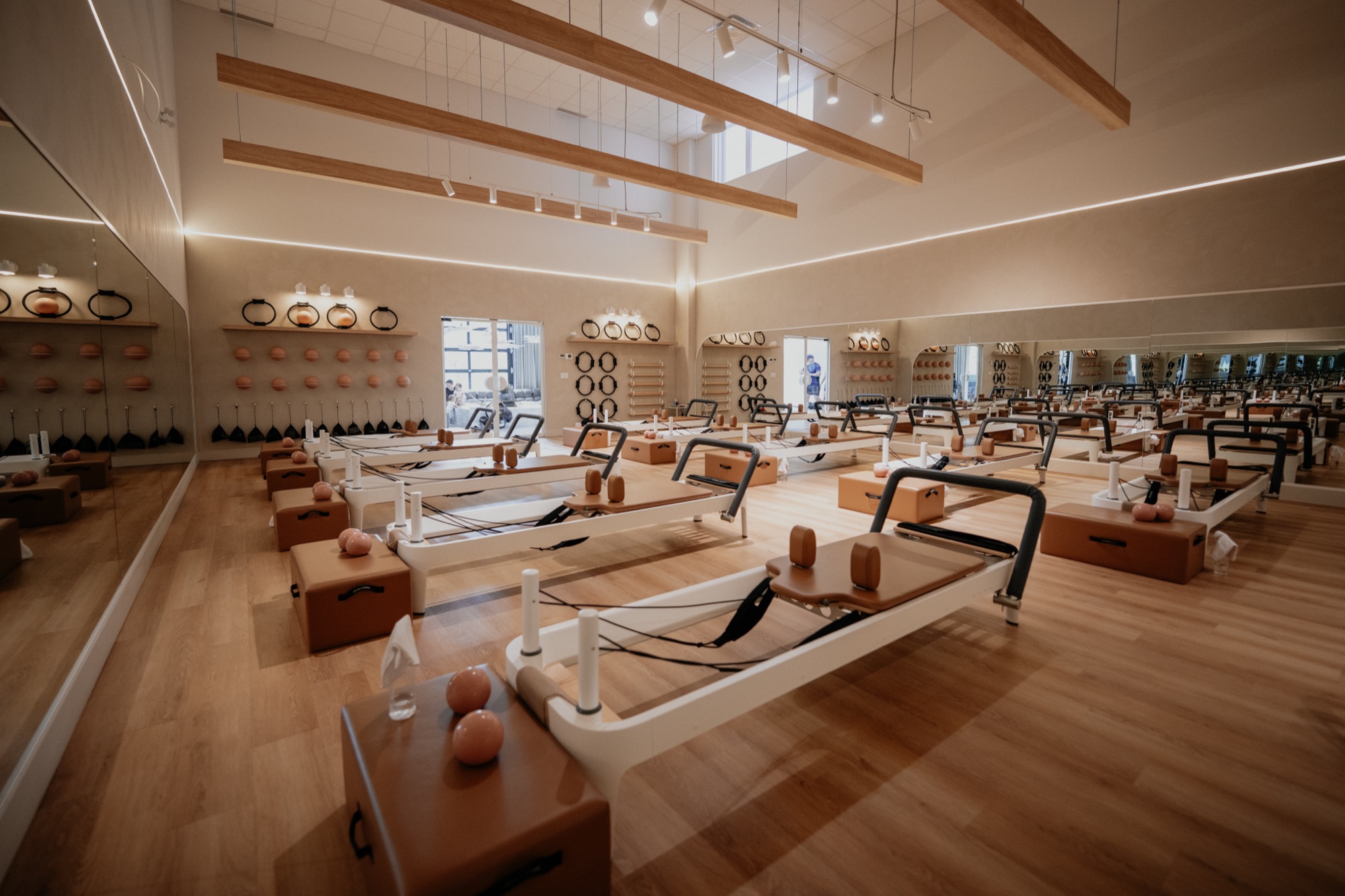 Cours de Pilates Reformer en groupe au studio Blackburn Pilates Bromont, reflet du logo BP au miroir