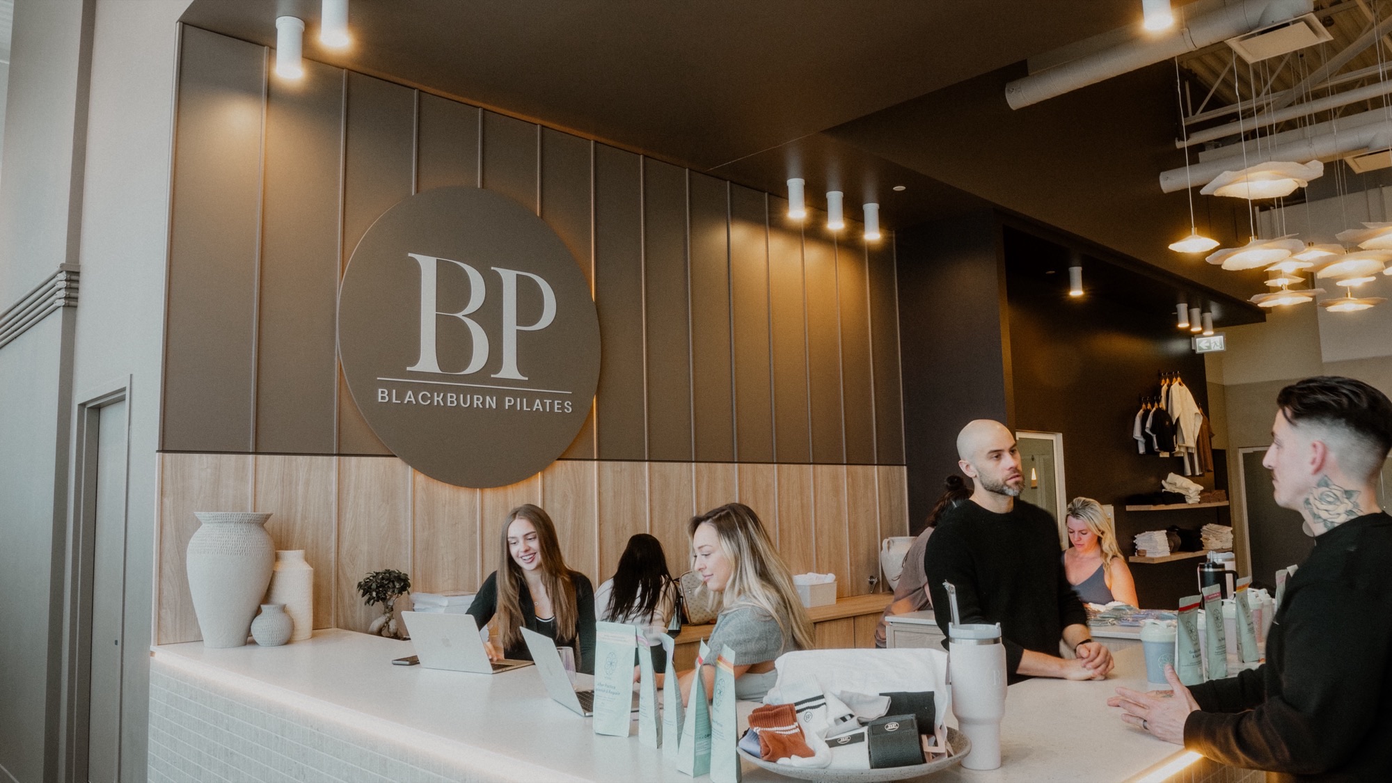 Accueil des membres au comptoir du studio Blackburn Pilates Saint-Bruno, sous le médaillon BP